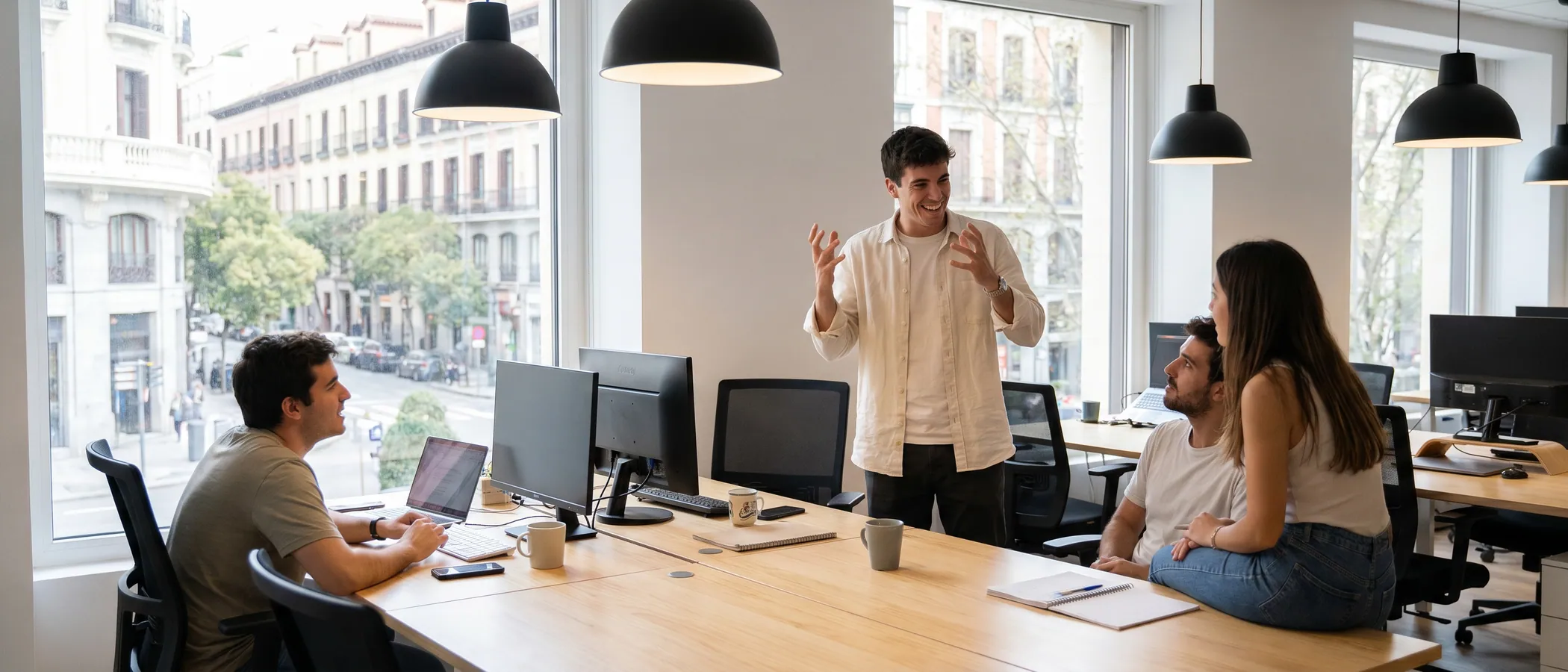 Tres companys d'una agència de màrqueting consulten junts una campanya de Google Ads en un portàtil