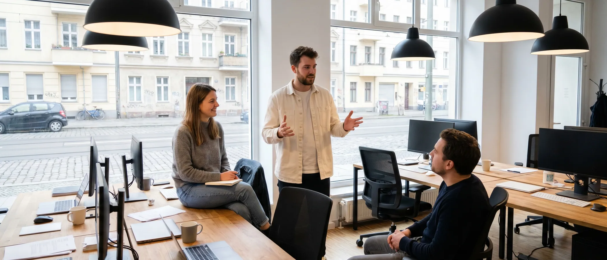 Drei Kollegen einer kleinen Marketing-Agentur schauen gemeinsam auf einen Laptop mit Google Ads