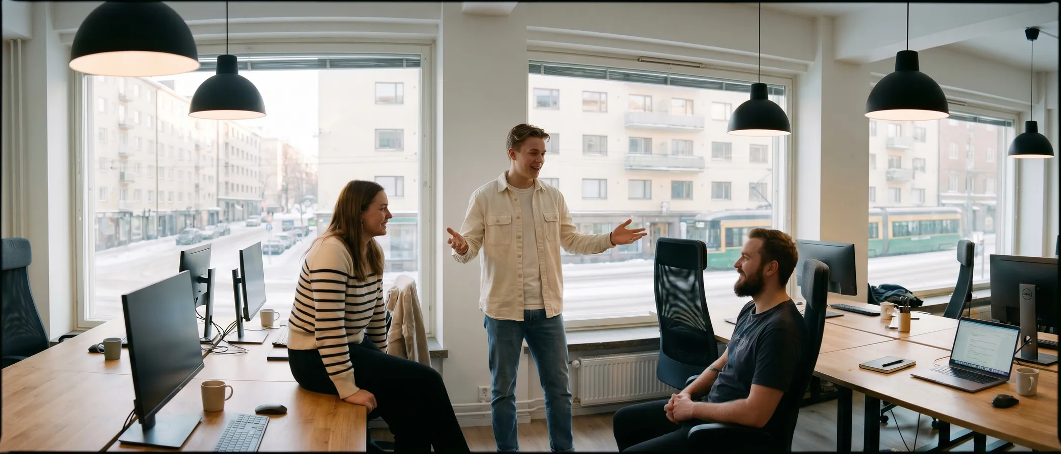 Kolme markkinointitoimiston työntekijää katsoo yhdessä kannettavaa tietokonetta ja hallinnoi Google Ads -kampanjoita