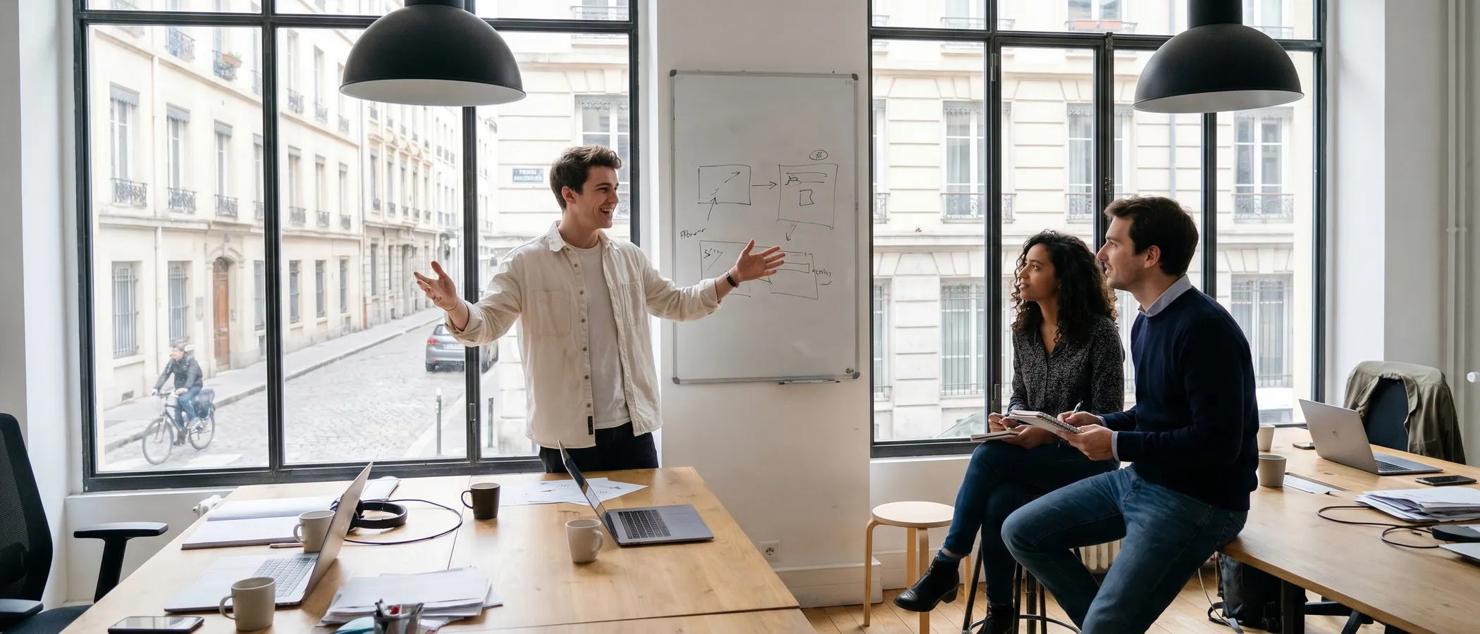 Trois collègues d'une agence marketing consultent ensemble des campagnes Google Ads sur un ordinateur portable