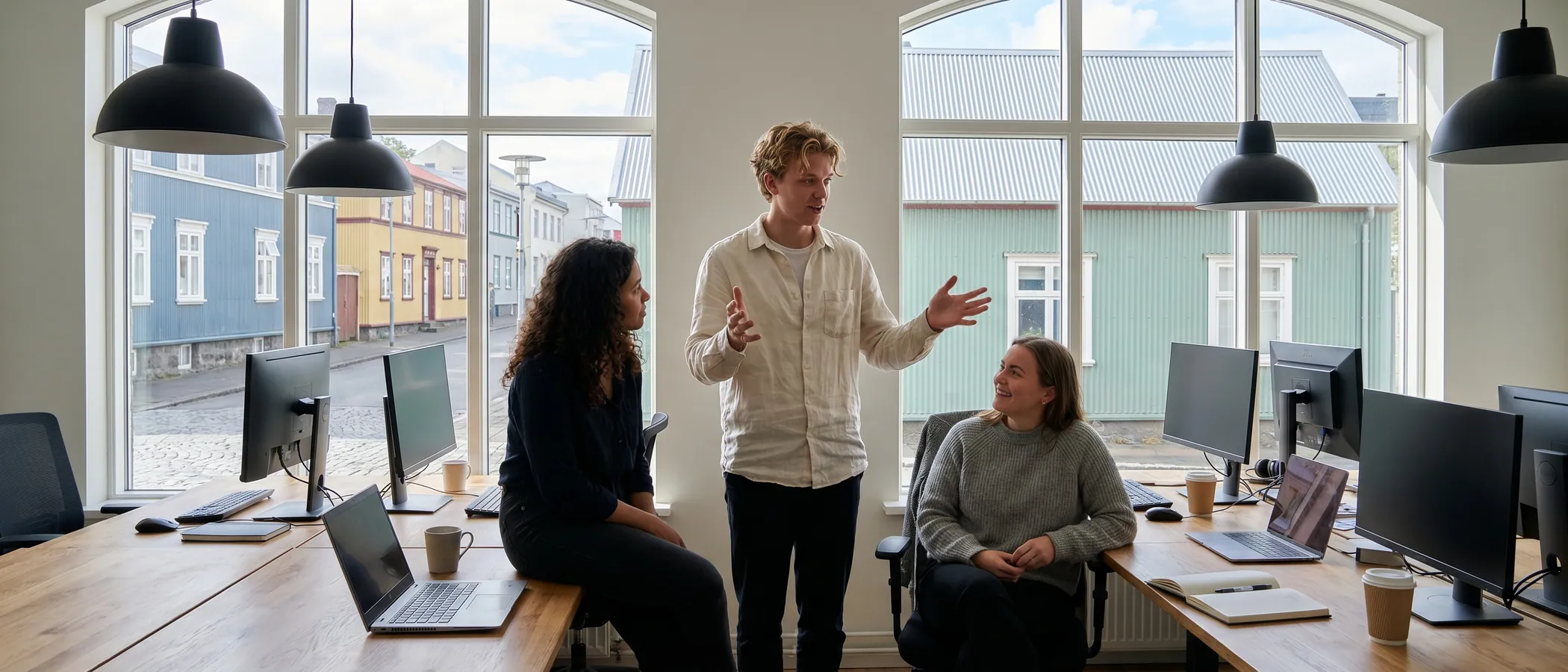 Þrír starfsmenn hjá litlu markaðsstofu skoða saman Google Ads á einni fartölvu
