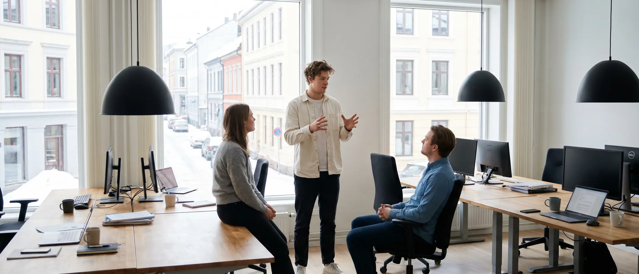 Tre kolleger på et lite markedsføringsbyrå ser på Google Ads-resultater sammen på én laptop