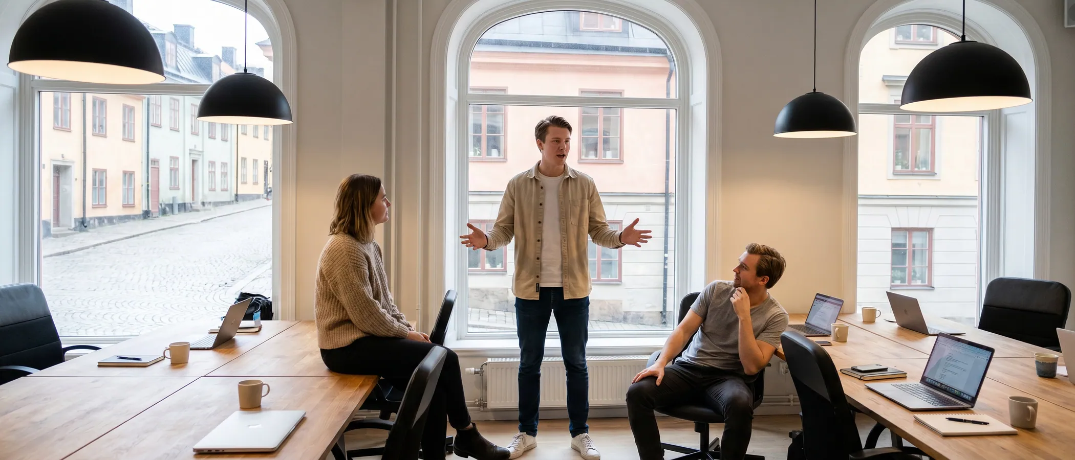 Tre kollegor på en marknadsföringsbyrå tittar tillsammans på en laptop med Google Ads-kampanjer